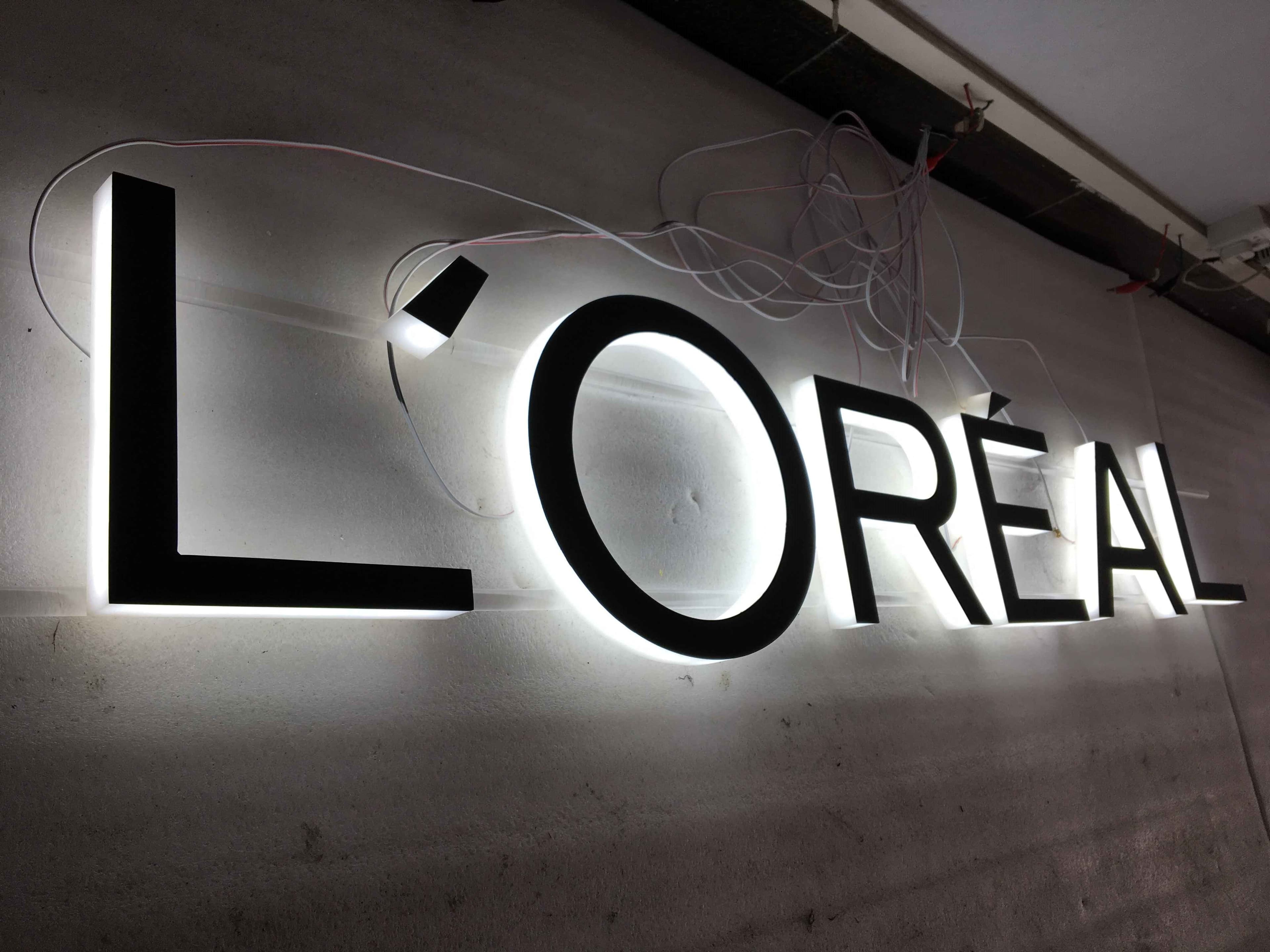 Real illuminated acrylic wall letters with visible wiring before finishing