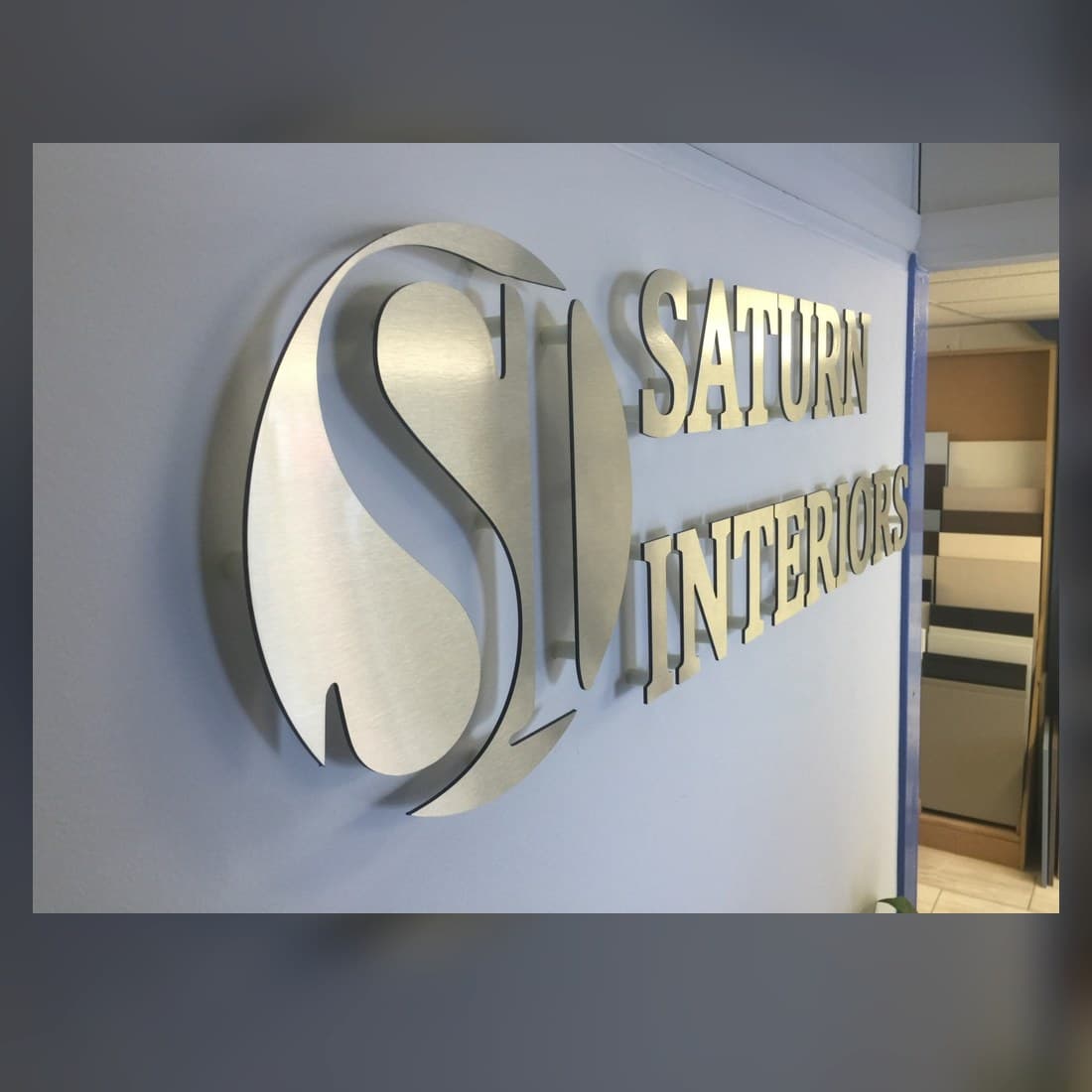 Real flat metal S logo and lettering mounted on an interior wall